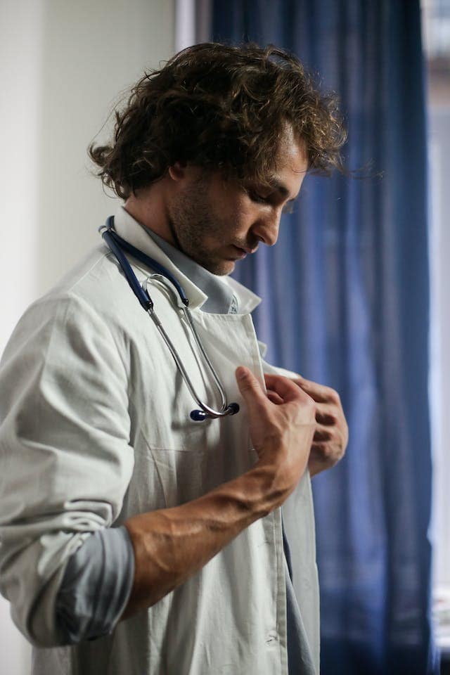 a doctor holding his doctor vest.