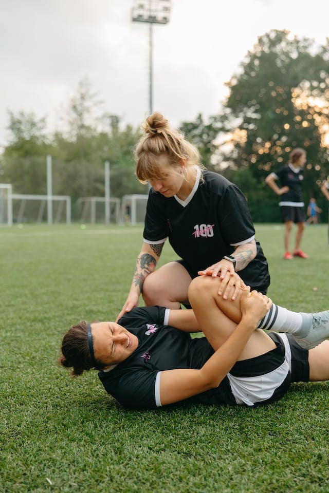 Knee Care : a man holding his knee and a woman comforting him. ACL Injuries. ACL Injuries in Football/Soccer