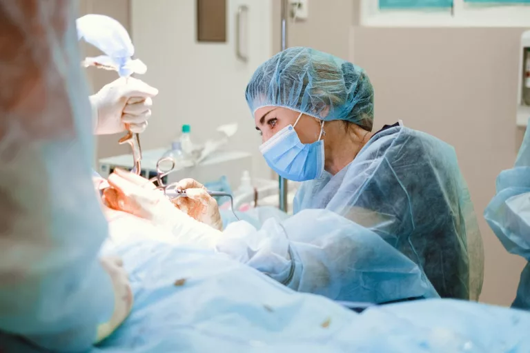 woman in front of patient being operated.