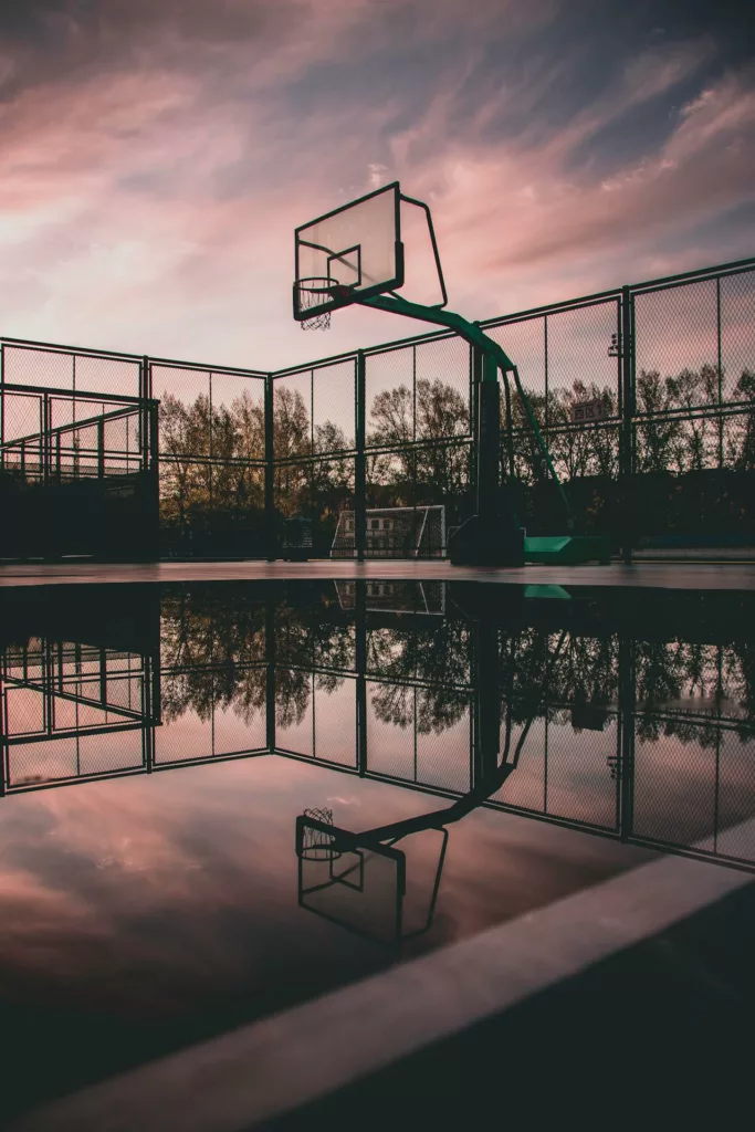 a basketball court reflecing the sky because of water on it